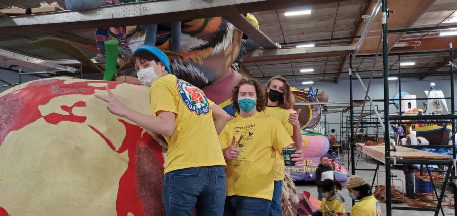 Burroughs Interact Club members (from left) junior Alex Vargas, junior Manuel Rodriguez, and senior Max Pogge decorate the apple/globe element on Rotary’s education-themed float.    