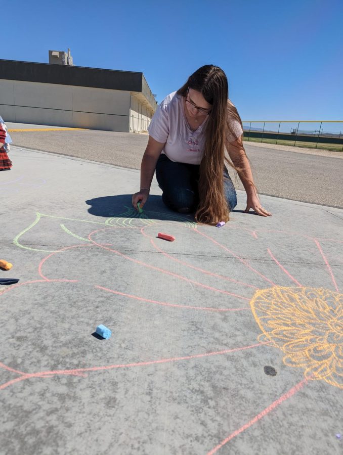 Victoria Ratliff drawing a flower with chalk.