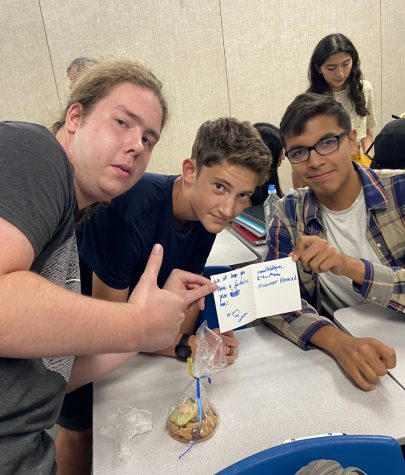 Senior Manuel Rodriguez (left) and juniors Eldon Mason and David Miranda show off the welcome card and cookies that they planned to give to a new teacher. 