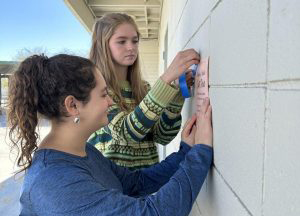 Friends of Rachel members Avery Thibado and Emma Kimbler advertise the annual FOR coat drive. 