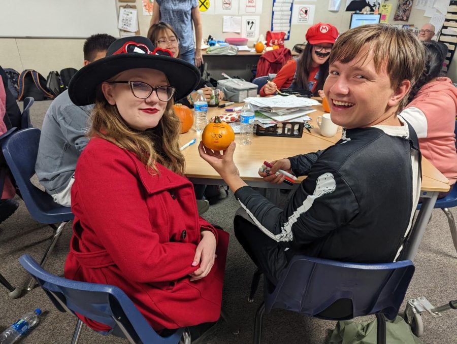 Junior Timothy Johnson (right) shows off the pumpkin he created with sophomore Interact Club member Nevaeh Hall (left). 