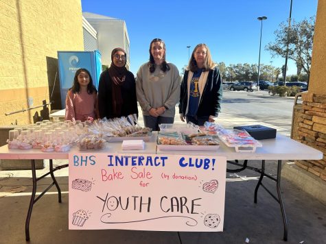 Freshman Emaan Ahmad (accompanied by her younger sister Zahra Ahmad), Junior Madison Ray, and Club advisor Judy Dwyer offer goods to the community for their YouthCare bake sale. 