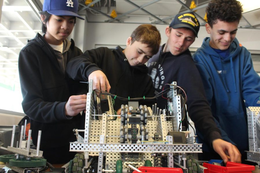 Freshmen Ian Patin, Patricks Boggs,  Jon Baronowski, and Tyler Torres work on their robot for upcoming Valentine’s competition. 