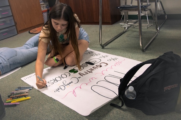 Freshman Class Co-President Taylor Johnson diligently works on a homecoming spirit week poster.   