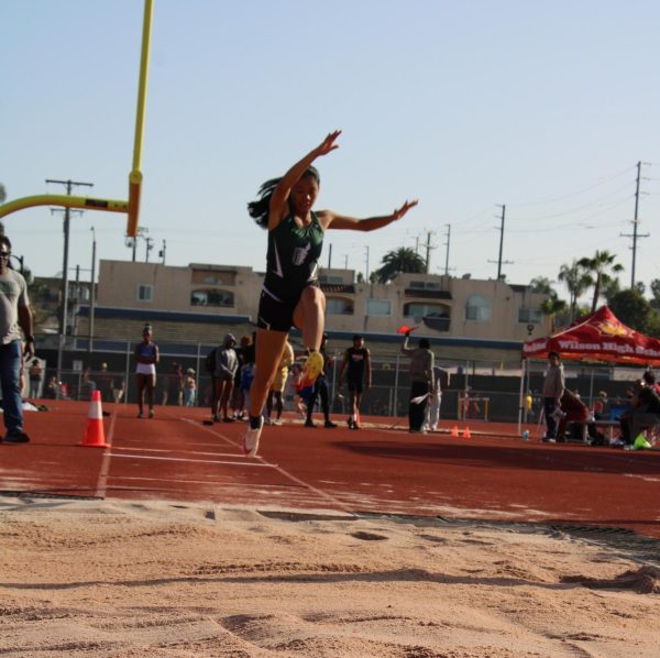 Junior Jhavmine Ave takes a giant leap during a Track and Field competition. 