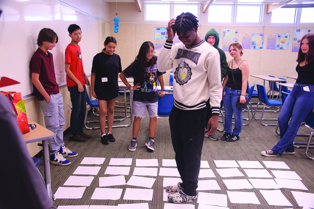 Freshman TJ Spivey  makes his way through an activity during Link Crew Orientation as his fellow ninth-graders look on.