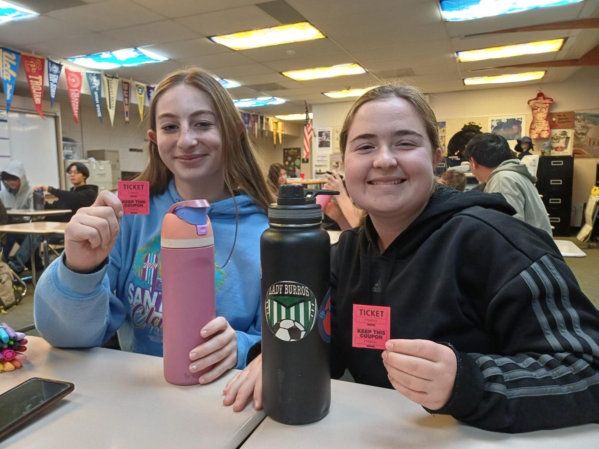 Sophomores Katie Brouchoud and Megan Ford proudly hold up the raffle tickets they earned by using reusable water bottles.