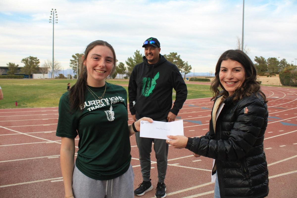 BHS Hurdler Brooklyn Sizemore and Coach Tony Martin accept a $10,000 donation on behalf of the track program from former BHS track star Marlene Avitia. 