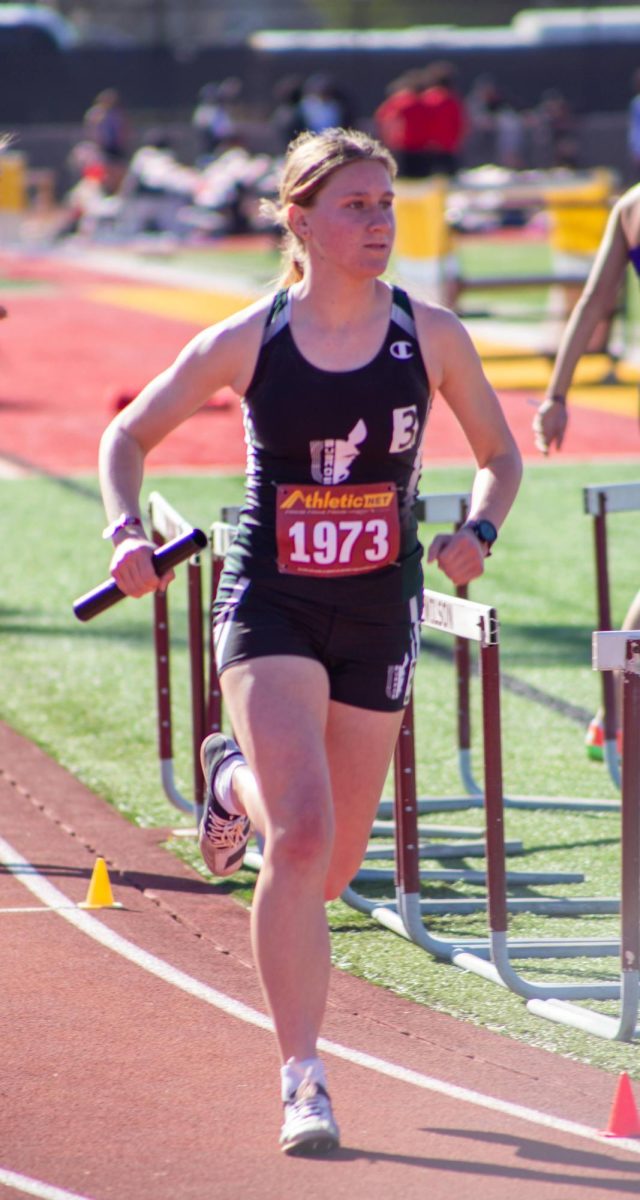 Eve Washburn takes off the start line, baton in hand, ready to dominate the track.