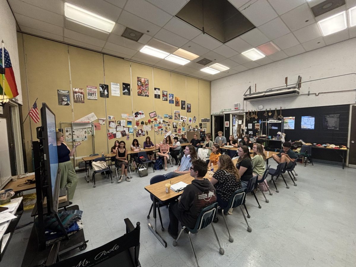 Drama Teacher Eileen Poole leads the cast through a table read. 