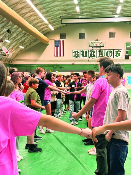 Link Leader Ishmael Gomez (center) helps unite incoming freshmen and his fellow pink-clad Link Leaders in a giant fist-bump line.