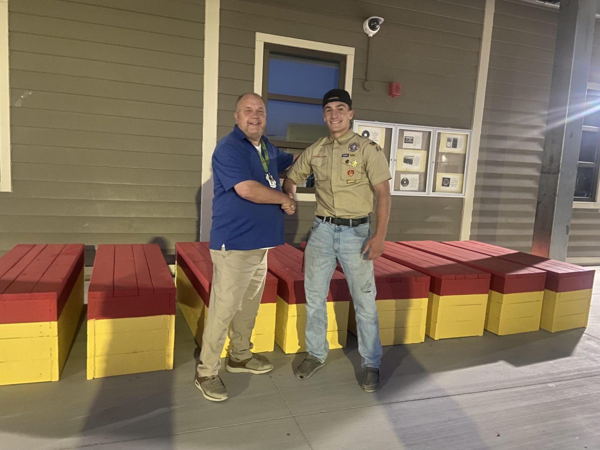 China Lake Junior High Principal David Andreason congratulates Burroughs junior Eli Eggleston on the completion of benches for China Lake Junior High.
