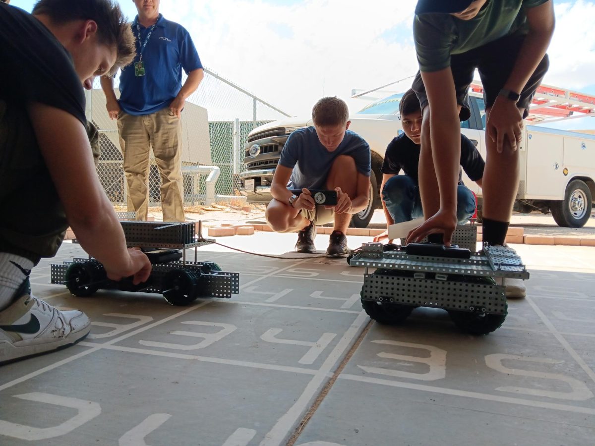 Students Everett Dicky(left) and Liam Staheli(right) set up their Tug-a-War robots for the final competition.