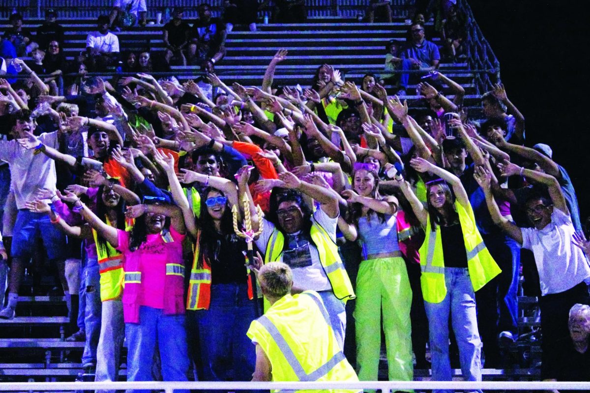 Senior Kanon Schiller gets the student section on their feet at the Sept. 5 football game against the West High Vikings.