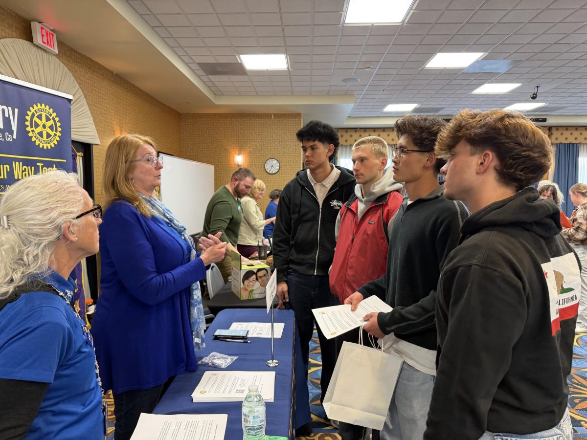 Seniors Duke Leon-Wegner, Miles Moroz, Dustin Bui, and junior Max Moroz gain information about scholarships from Rotary.